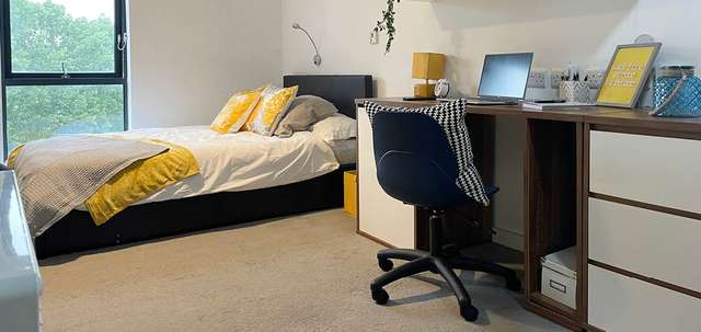 Bed, desk and laptop in student accommodation