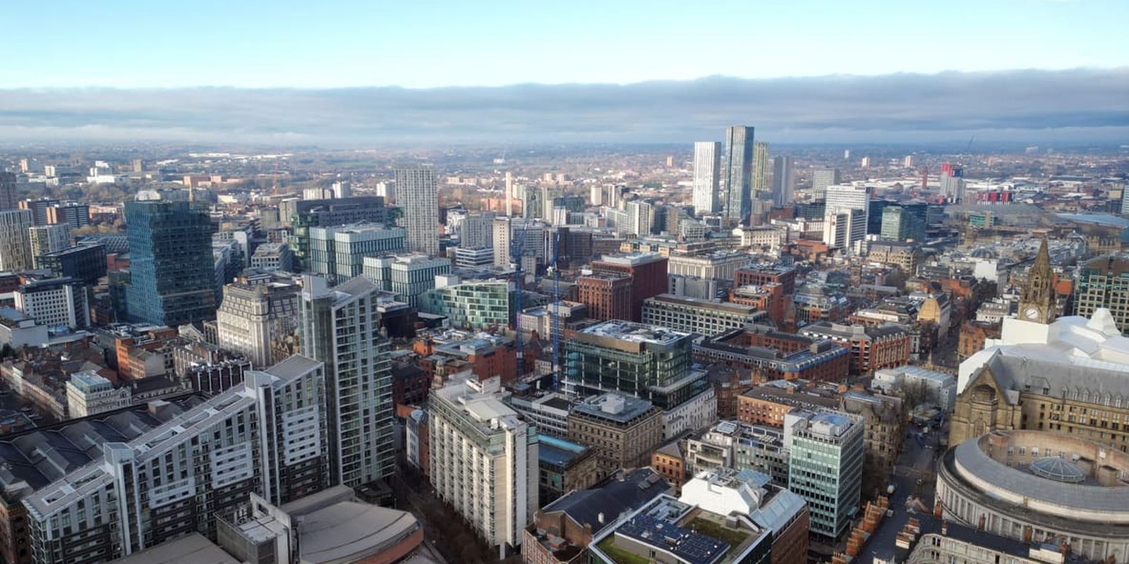 Aerial drone shot across Manchester shot from the west looking east at Deansgate Square, Manchester
