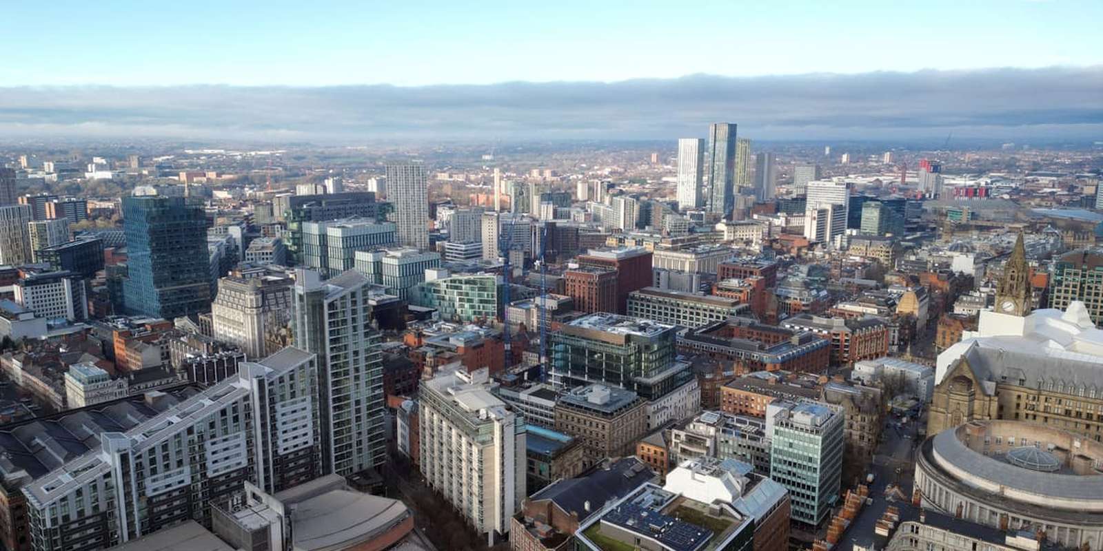 Aerial drone shot across Manchester shot from the west looking east at Deansgate Square, Manchester