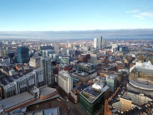 Aerial drone shot across Manchester shot from the west looking east at Deansgate Square, Manchester