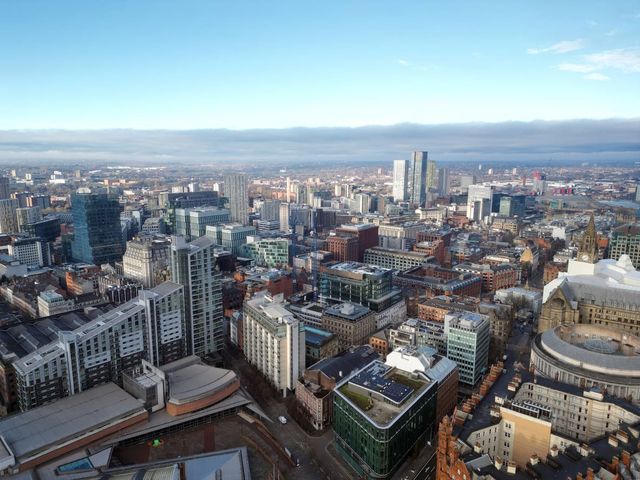Aerial drone shot across Manchester shot from the west looking east at Deansgate Square, Manchester