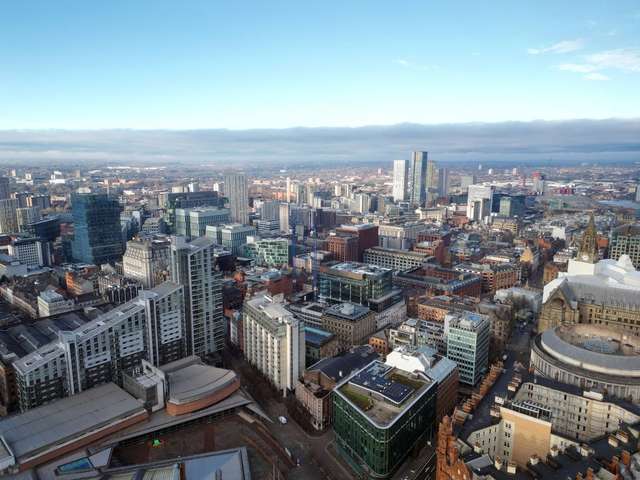 Aerial drone shot across Manchester shot from the west looking east at Deansgate Square, Manchester