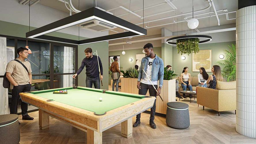 Young adults playing pool and socializing in a modern lounge with green walls, plants, and comfortable seating.