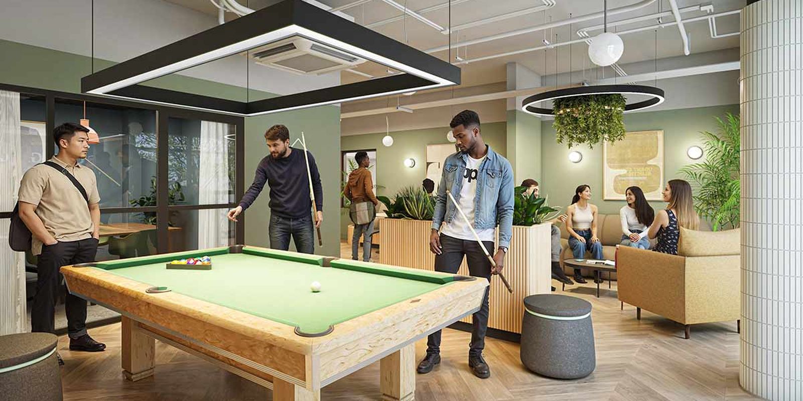 Young adults playing pool and socializing in a modern lounge with green walls, plants, and comfortable seating.