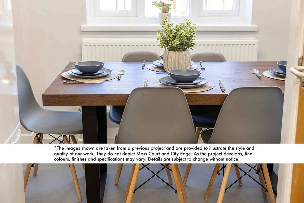 A dining table with six gray chairs, neatly set with dark plates, bowls, and utensils. A potted plant centerpiece is on the wooden tabletop.