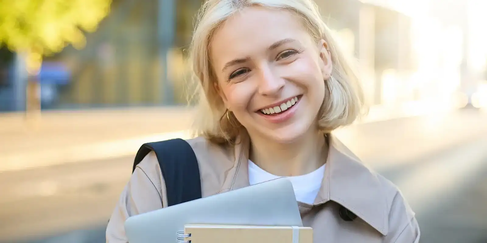 Close up image of smiling student with laptop and notepad