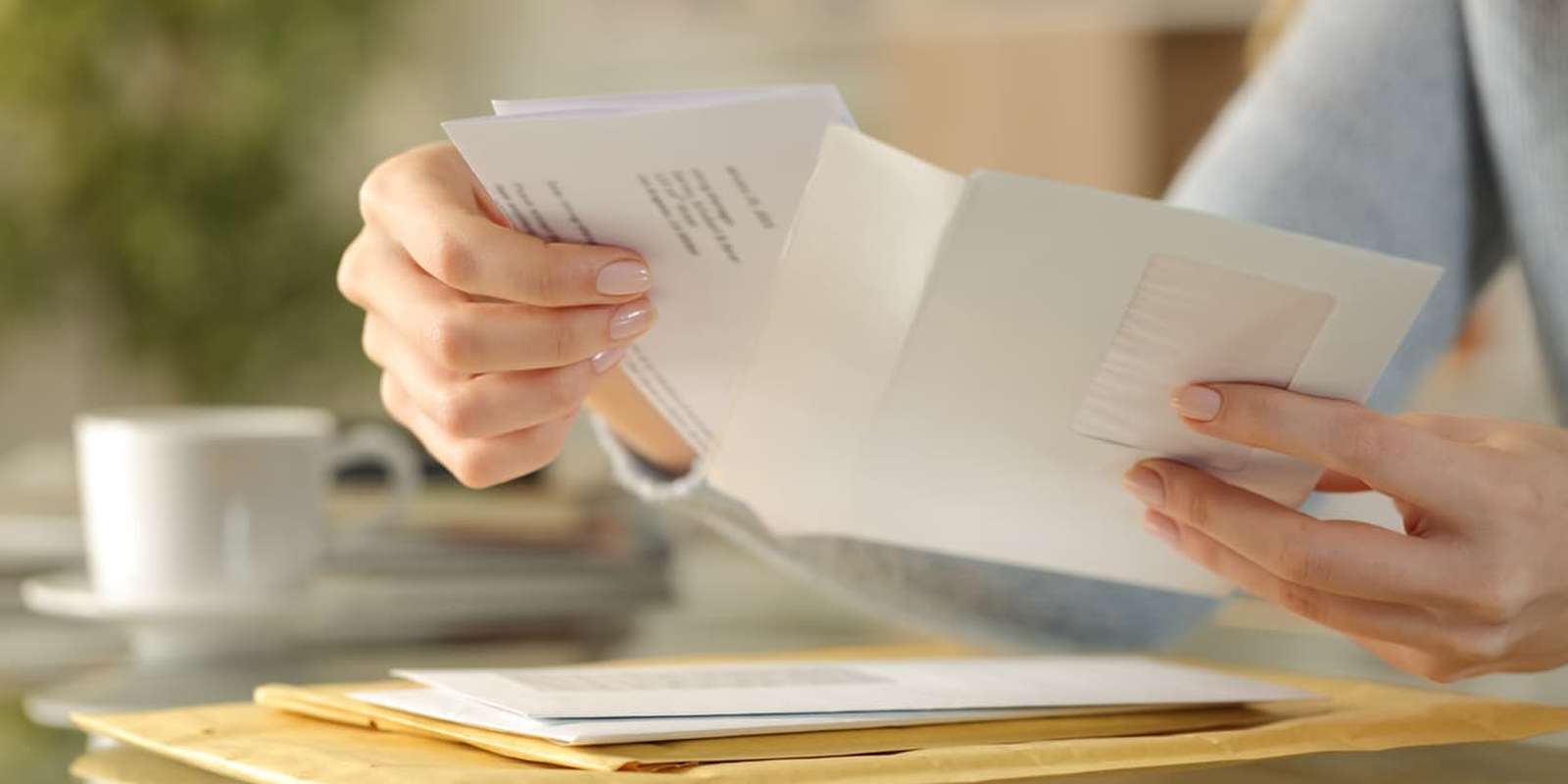 Girl hands opening an envelope on a desk