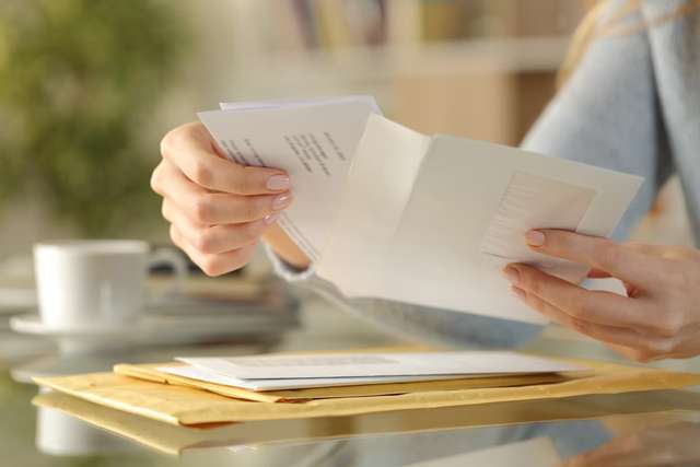 Girl hands opening an envelope on a desk