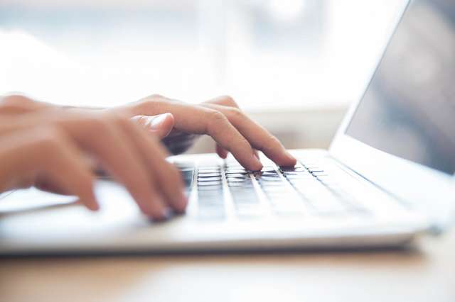 Student typing on laptop