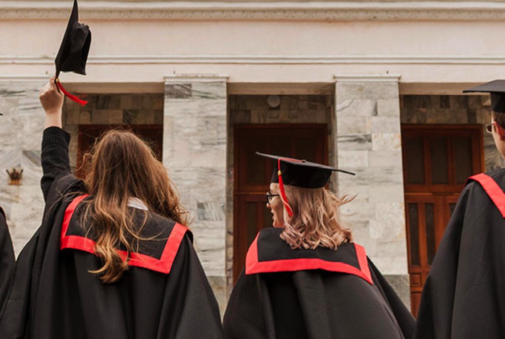 Group of four student in graduate gowns