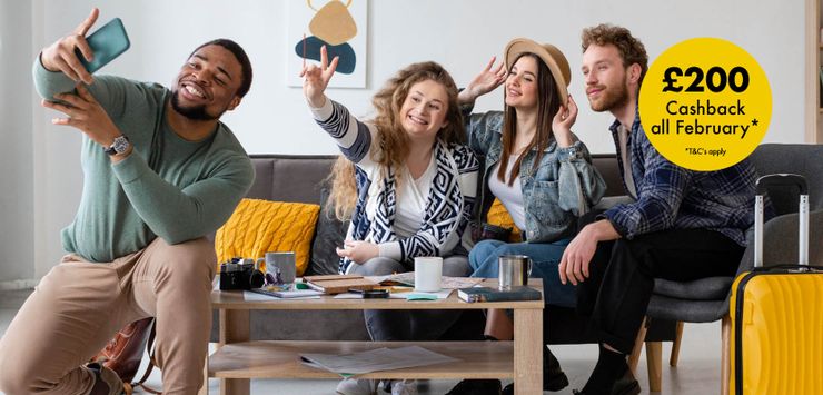 Four friends smile and pose for a selfie in a living room. A yellow circle advertises £200 cashback available all February.