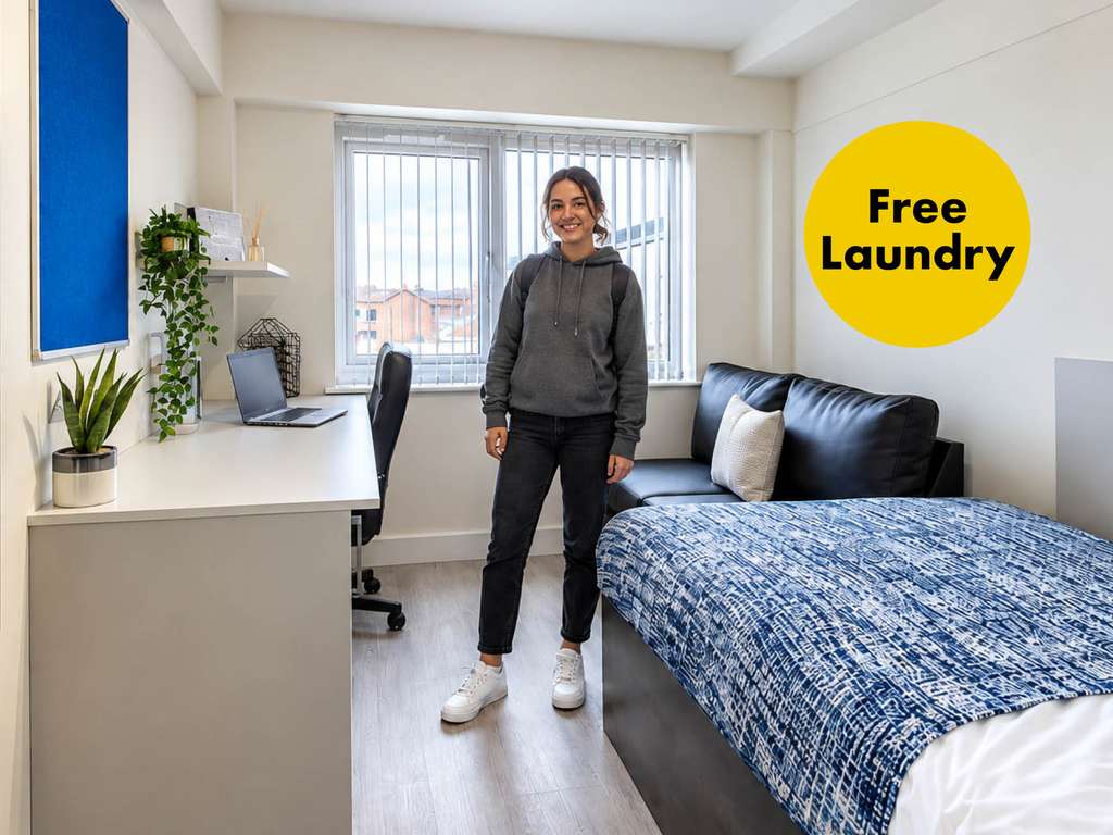 A person stands in a tidy dorm room with a bed, desk, plants, and laptop. A yellow circle reads "Free Laundry."