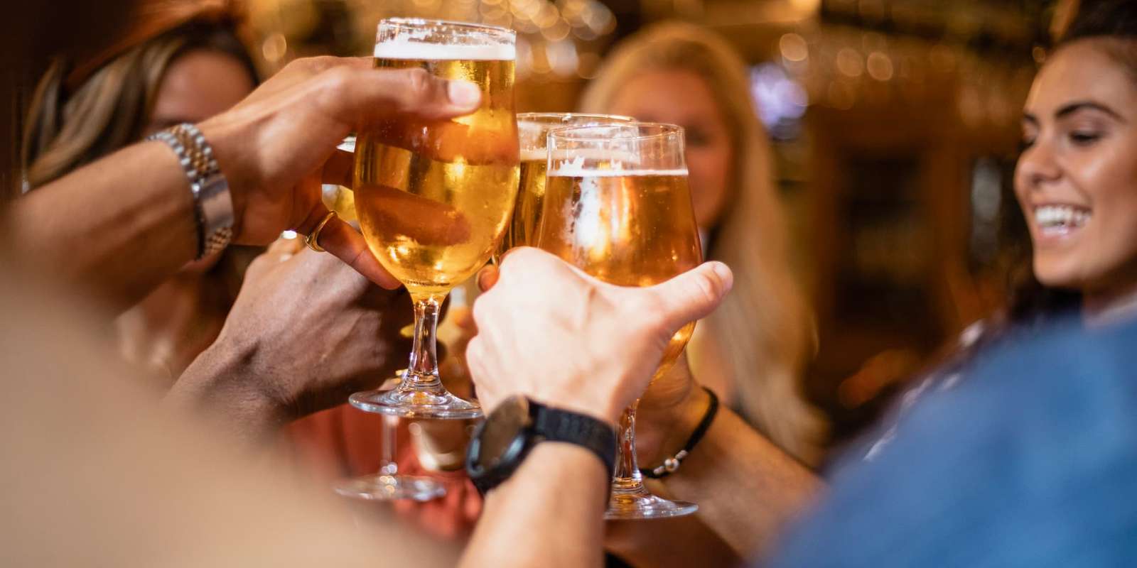 Group of students toasting pints of lager