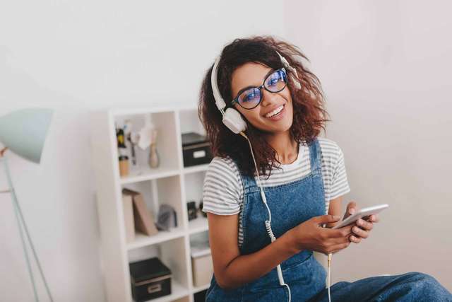 enthusiastic-girl-striped-shirt-listening-music-front-wall