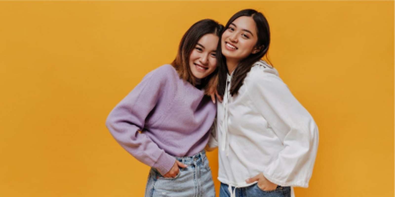 Two young students with a yellow background