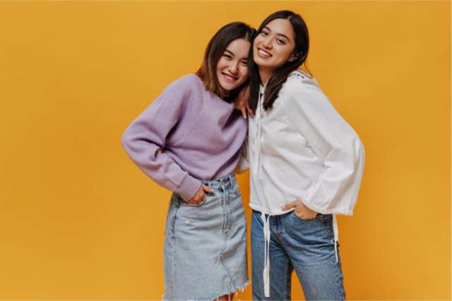 Two young students with a yellow background
