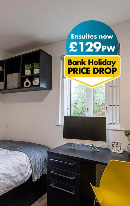 Modern bedroom with a desk, yellow chair, wall shelves, and a window. Text overlay: "Ensuites now £129PW, Bank Holiday PRICE DROP."