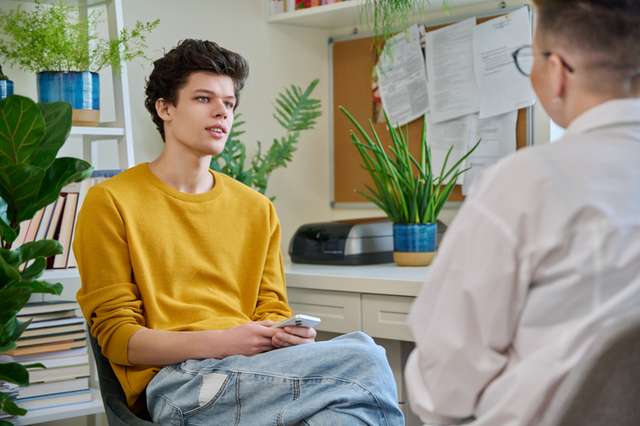 College student guy at meeting with professional counselor