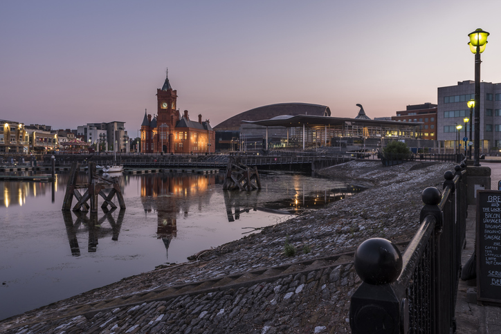 Cardiff bay pier head building lit up and reflecting on the water
