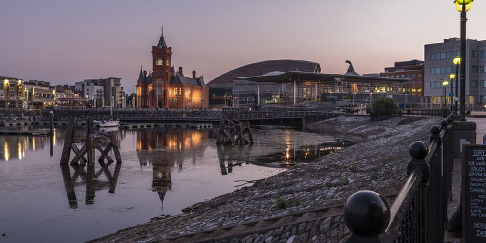 Cardiff bay pier head building lit up and reflecting on the water