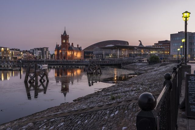 Cardiff bay pier head building lit up and reflecting on the water