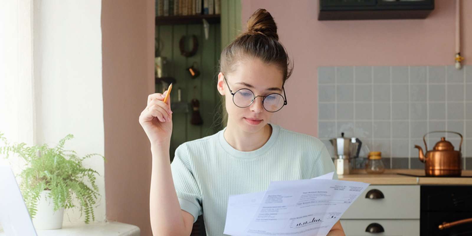 A young European woman sitting at a table looking at finances