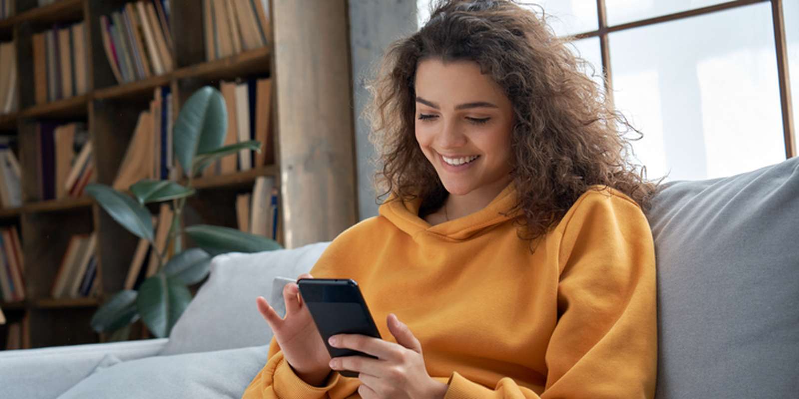 Student on a sofa looking at her phone
