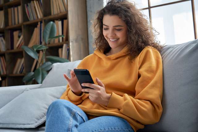 Student on a sofa looking at her phone