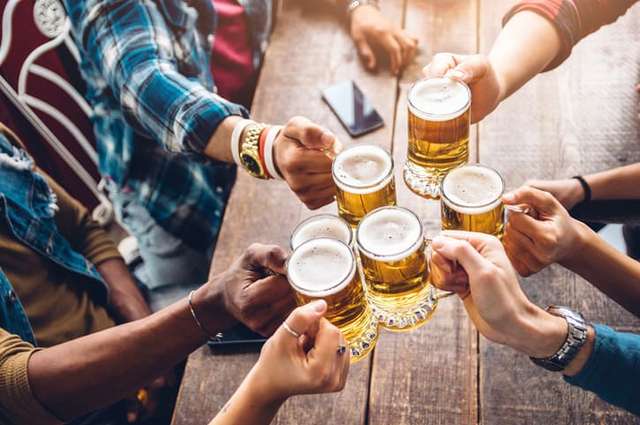 Group of people enjoying and toasting a beer