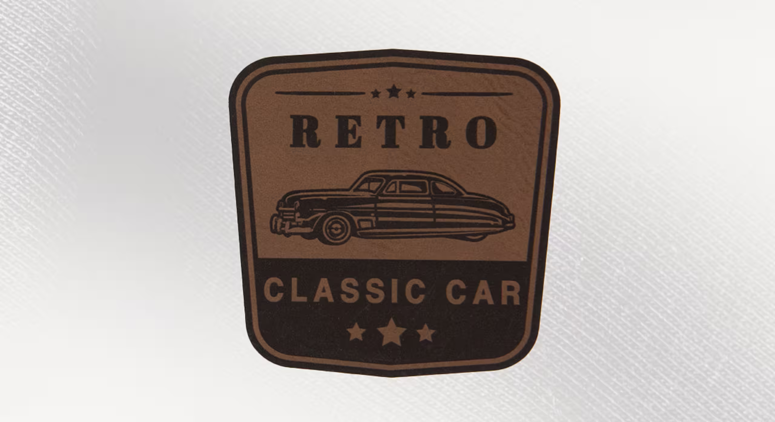 a chocolate leather patch of a retro car and the words classic car