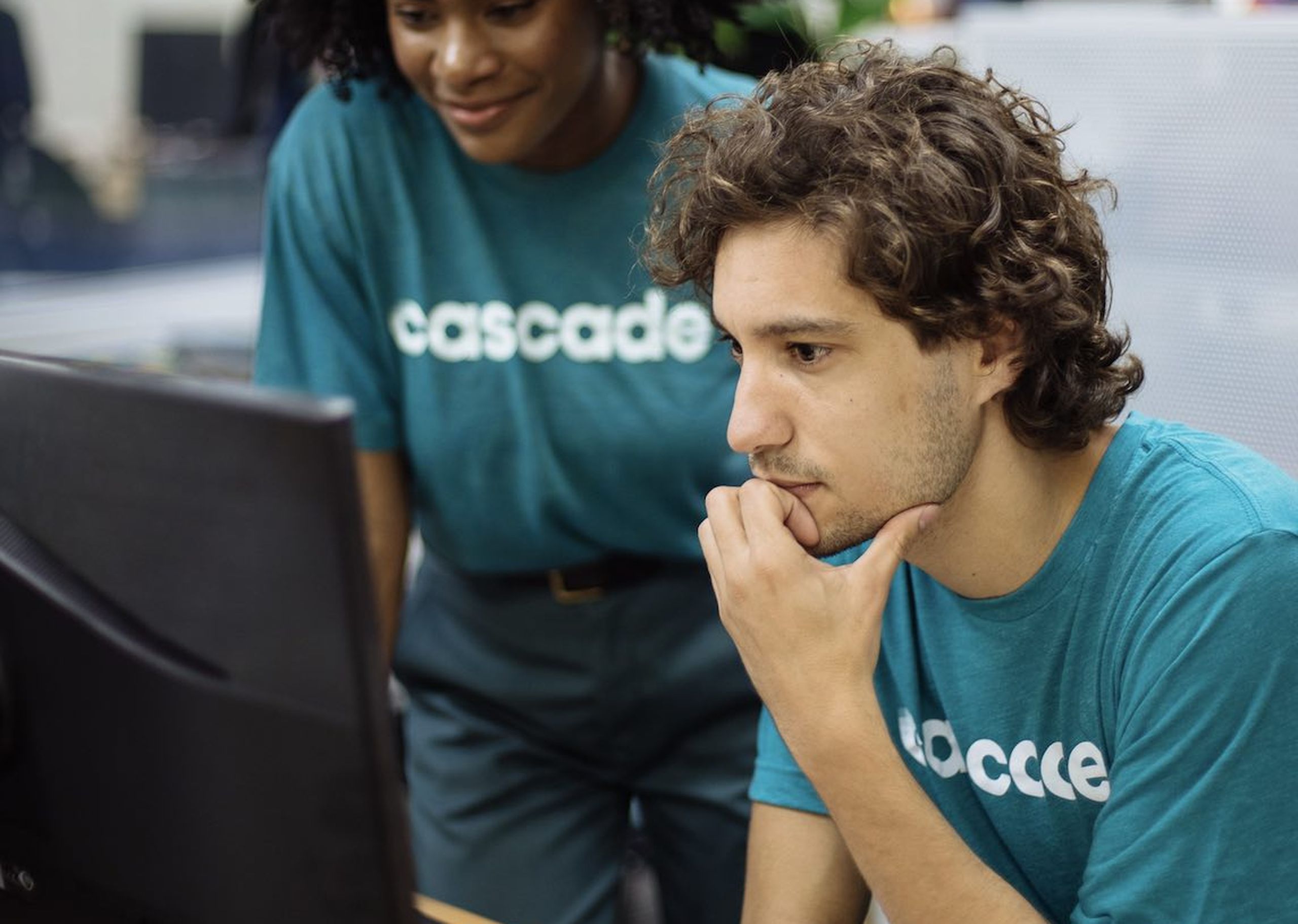 A woman and a man work together while wearing matching t-shirts for their company