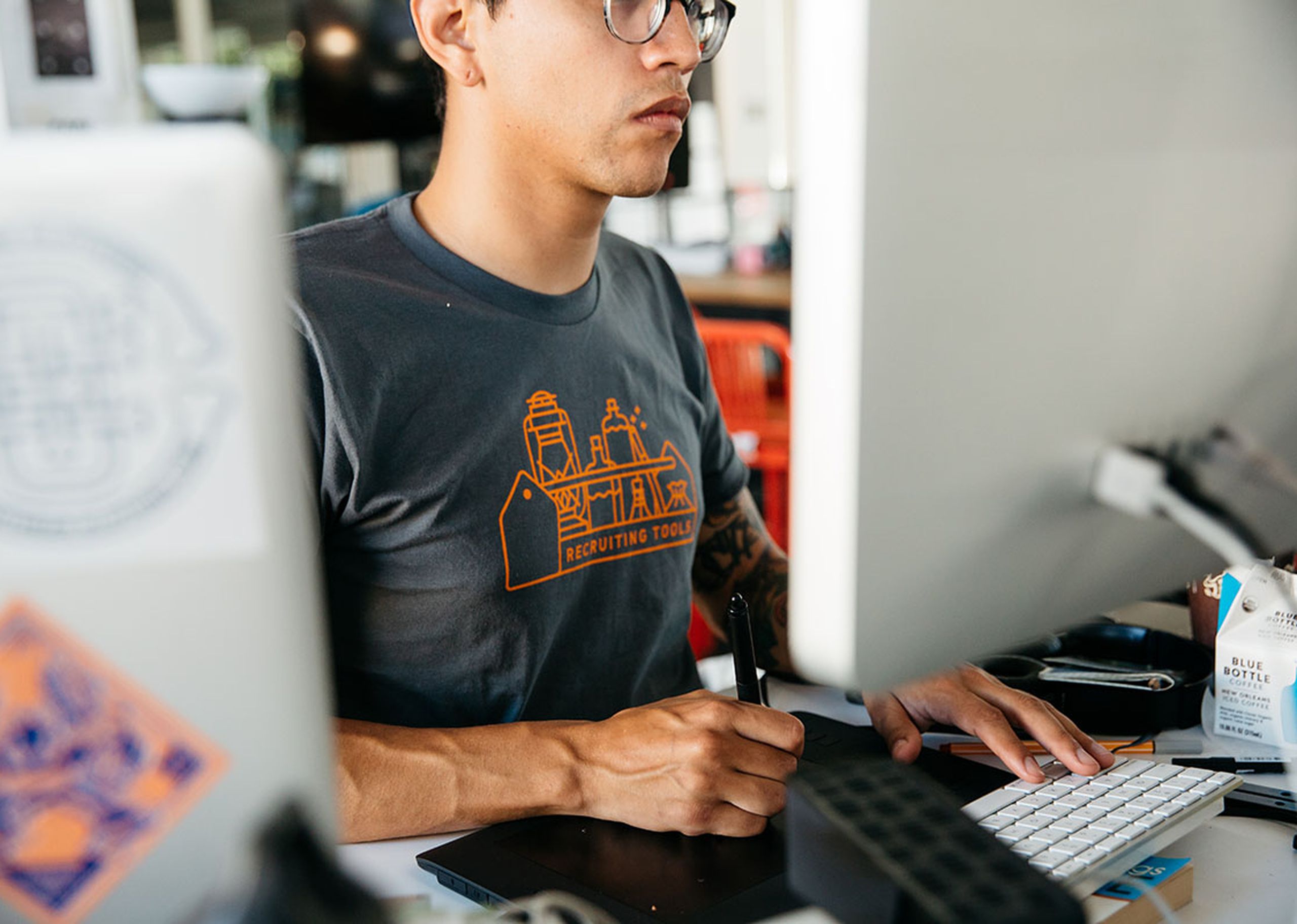 Someone working for a remote job, while wearing a custom t-shirt that says "recruiting tools"