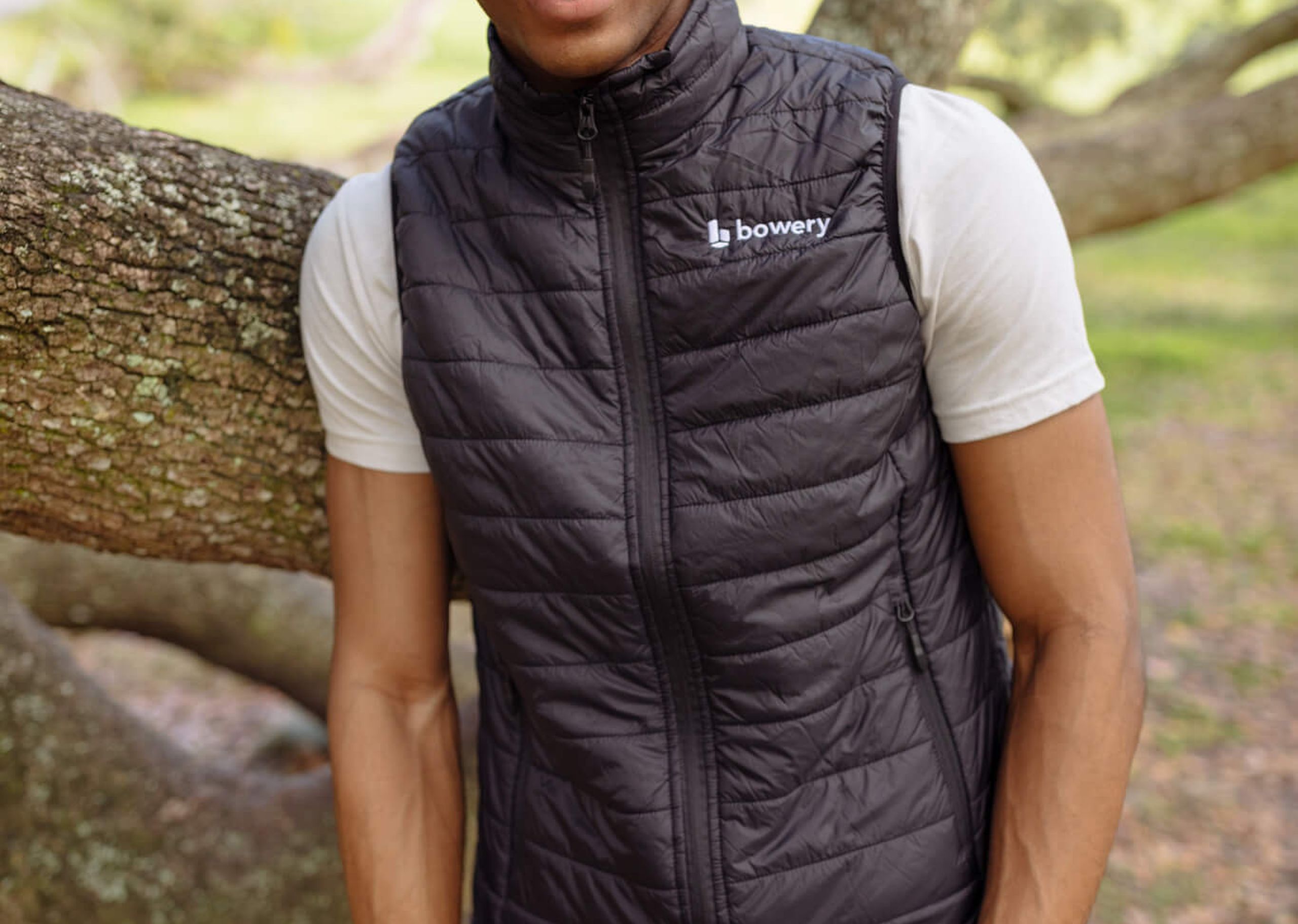 a man wearing a black vest with Bowery embroidered on the top right chest