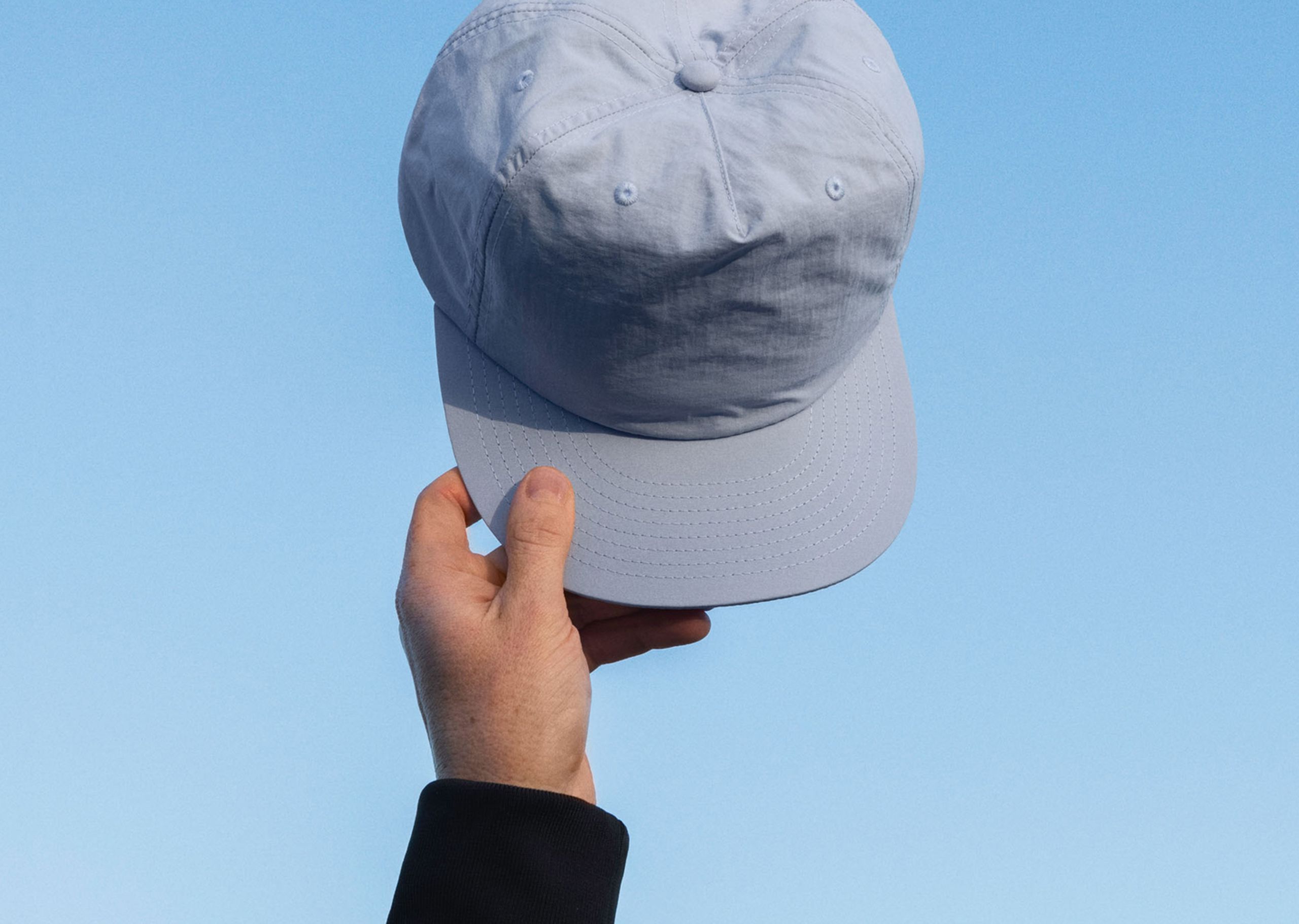 someone holding the as colour 1114 surf cap in the air