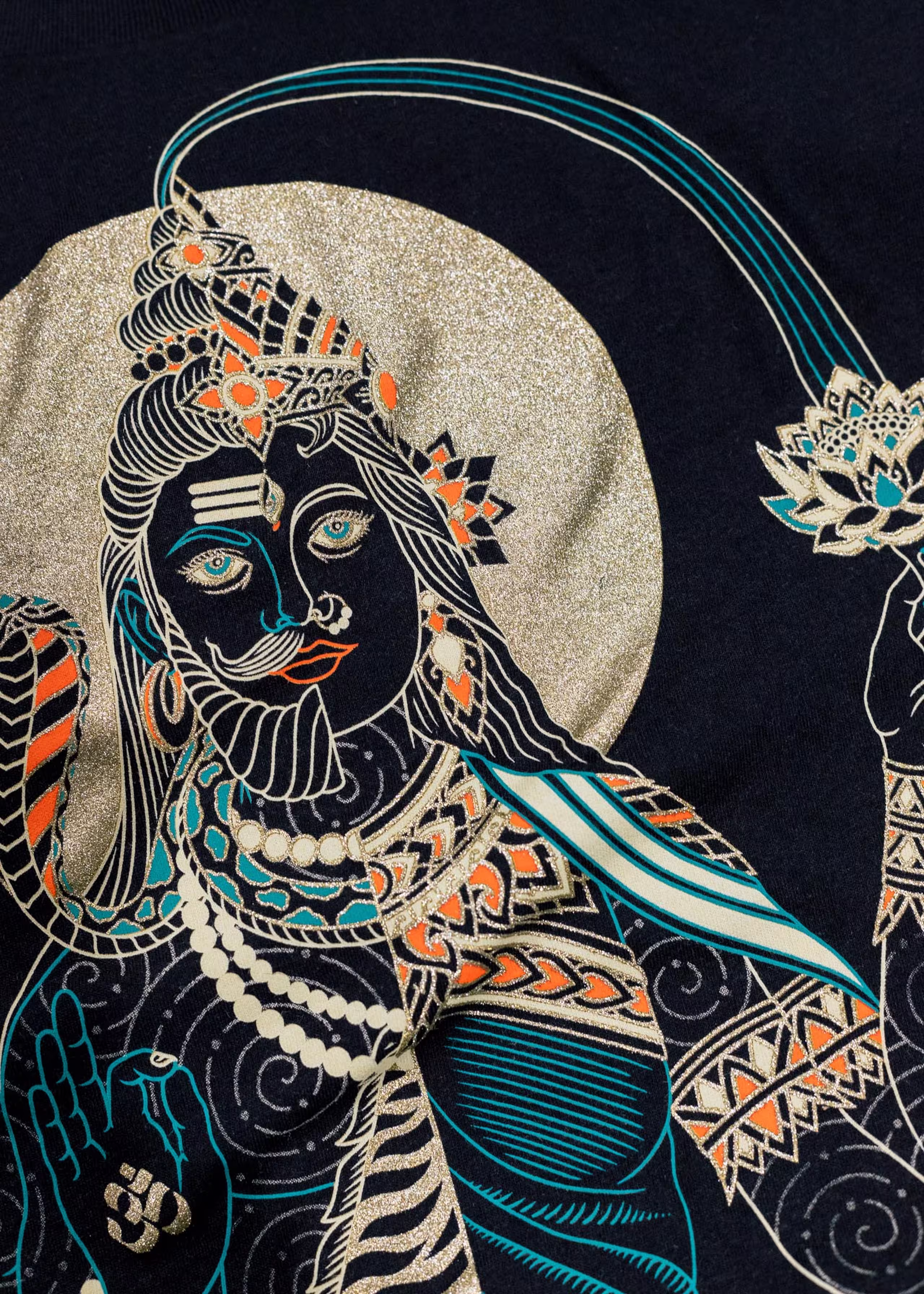 A close-up of a shirt with a colorful design, containing a gold metallic ink