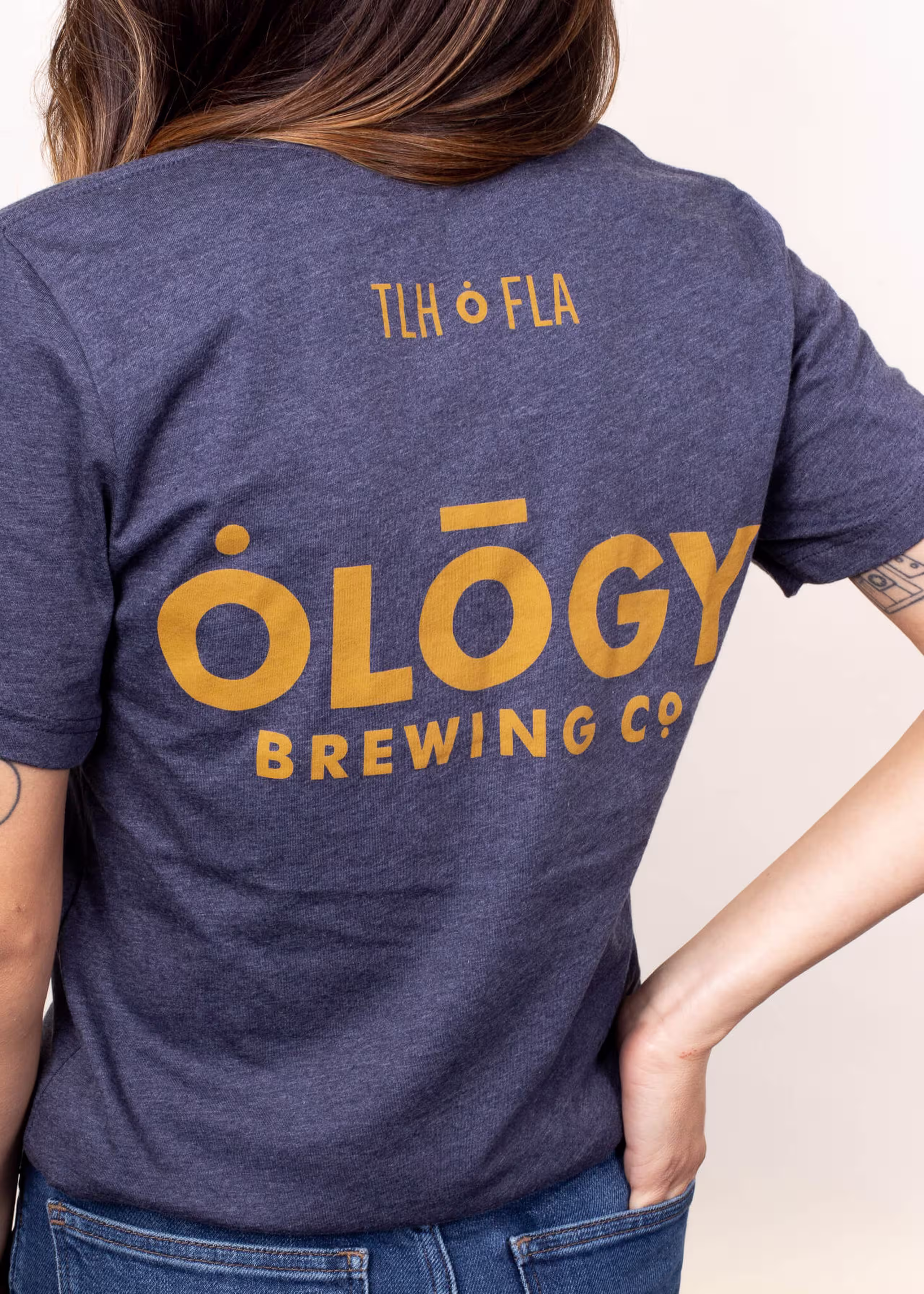 woman wearing a blue tee with gold letters