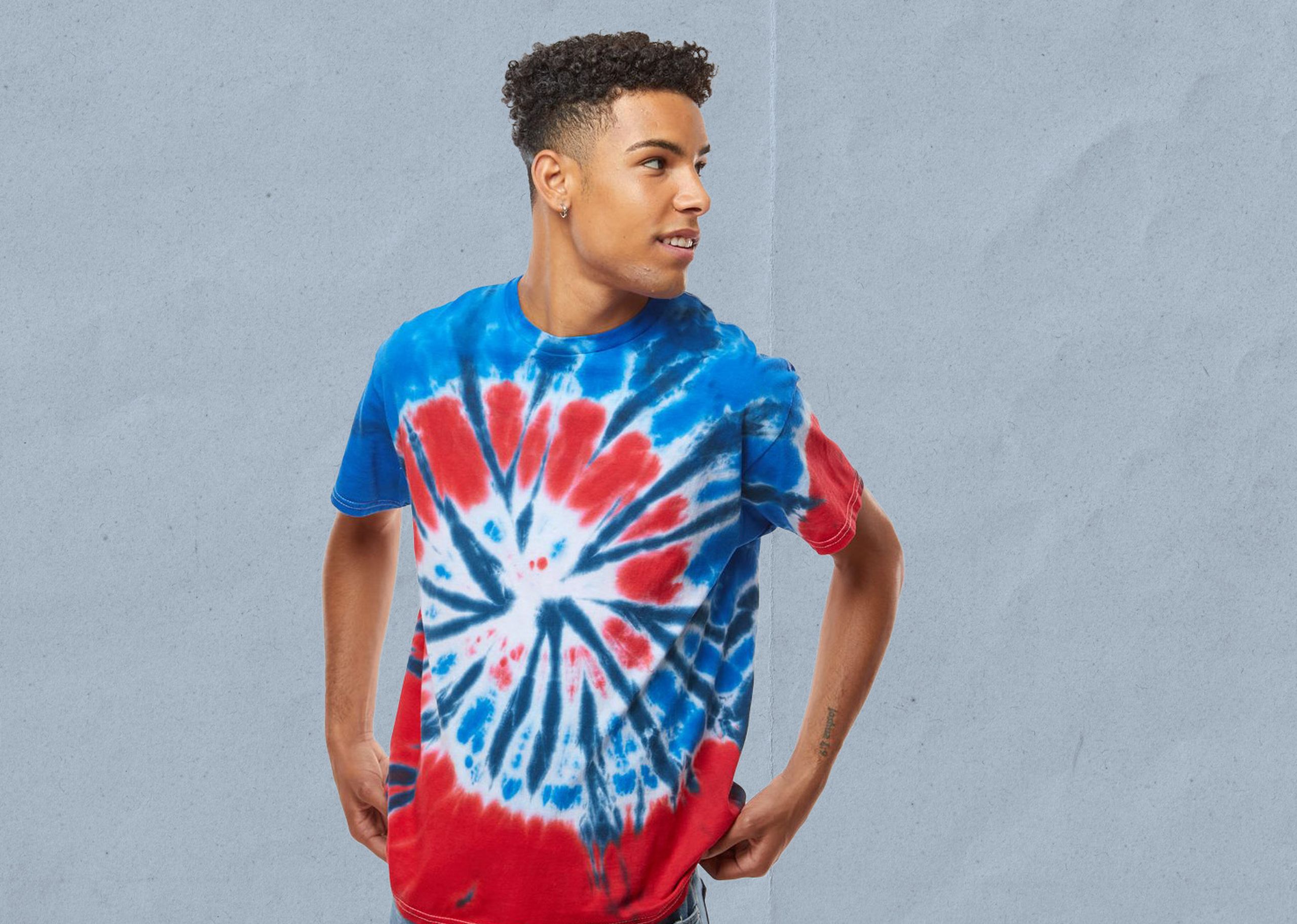 a man wearing a blue and red tie-dyed t-shirt in front of a blue background