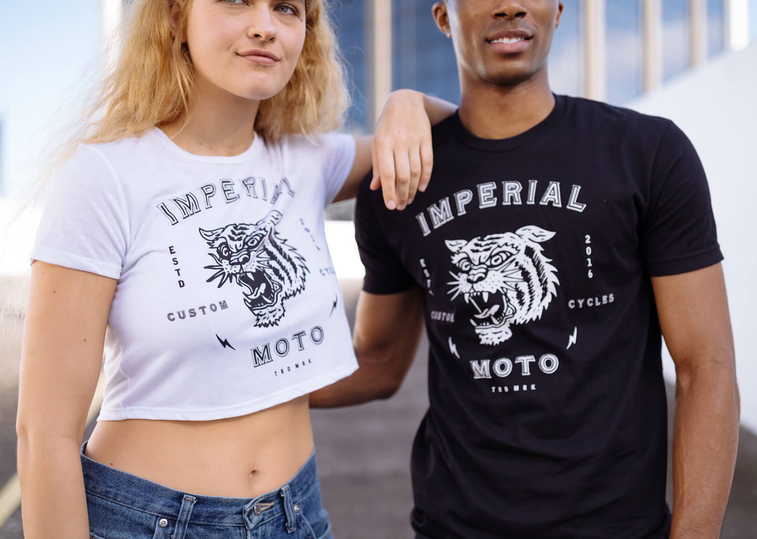 women wearing a cropped white t-shirt and a man wearing a black t-shirt