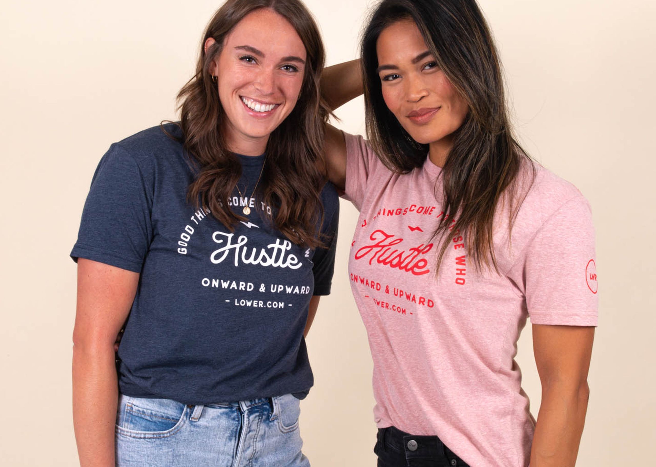 Two girls wear matching shirts that say "hustle," one blue shirt, one pink