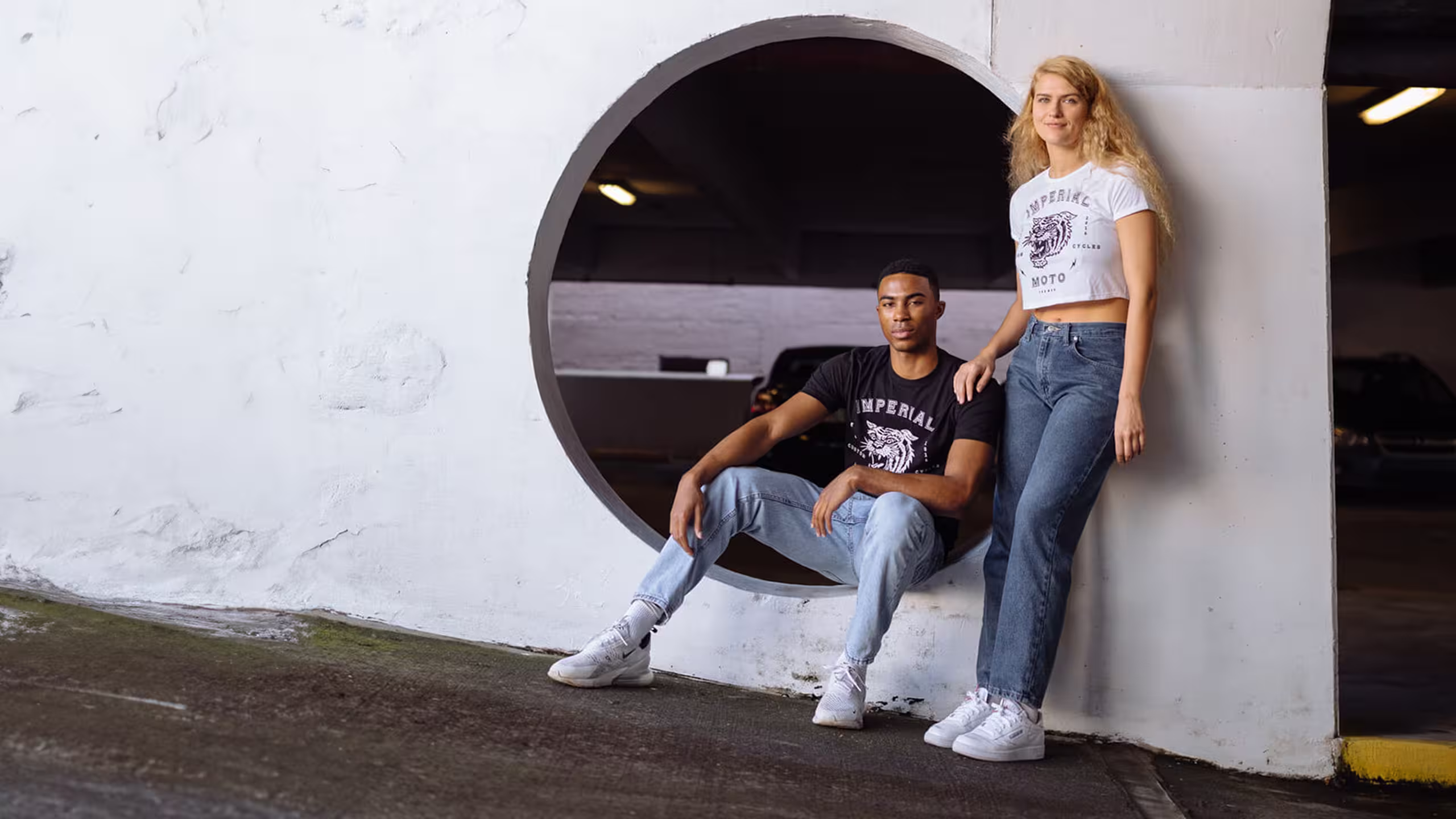 man wearing a black unisex t-shirt and a woman wearing a white woman cut t-shirt