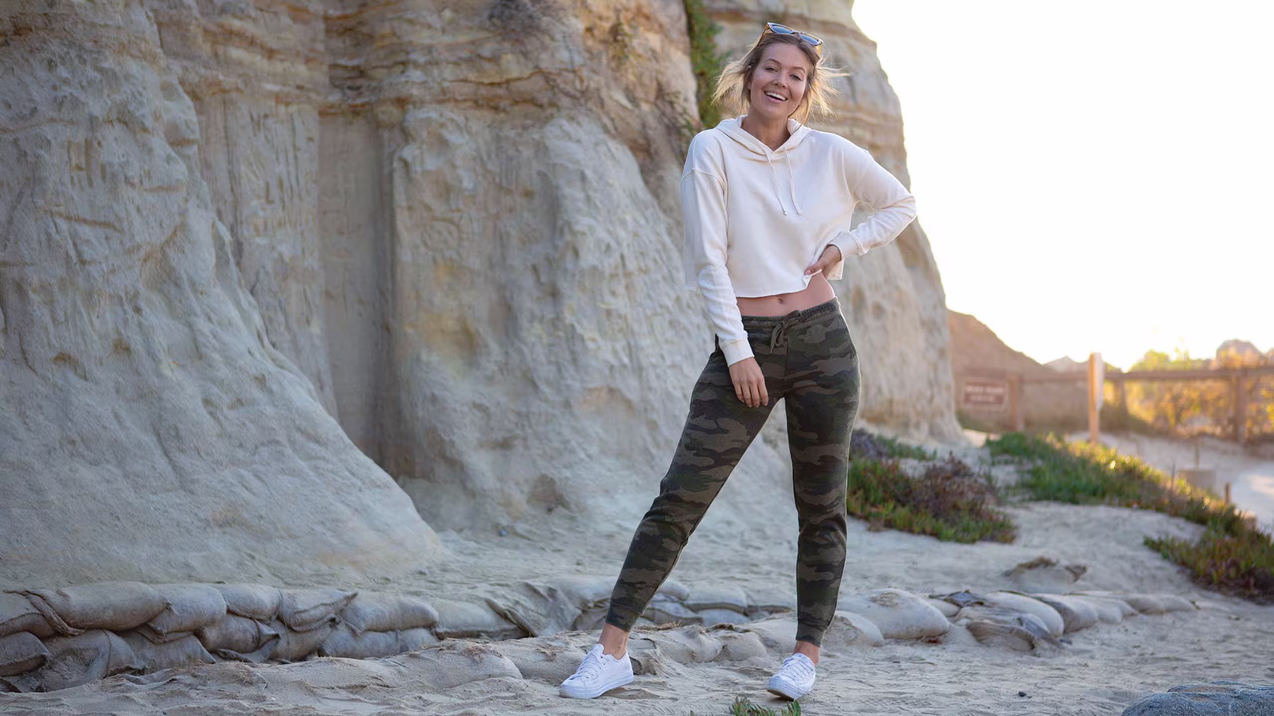 women wearing a white crop sweatshirt with camo sweatpants