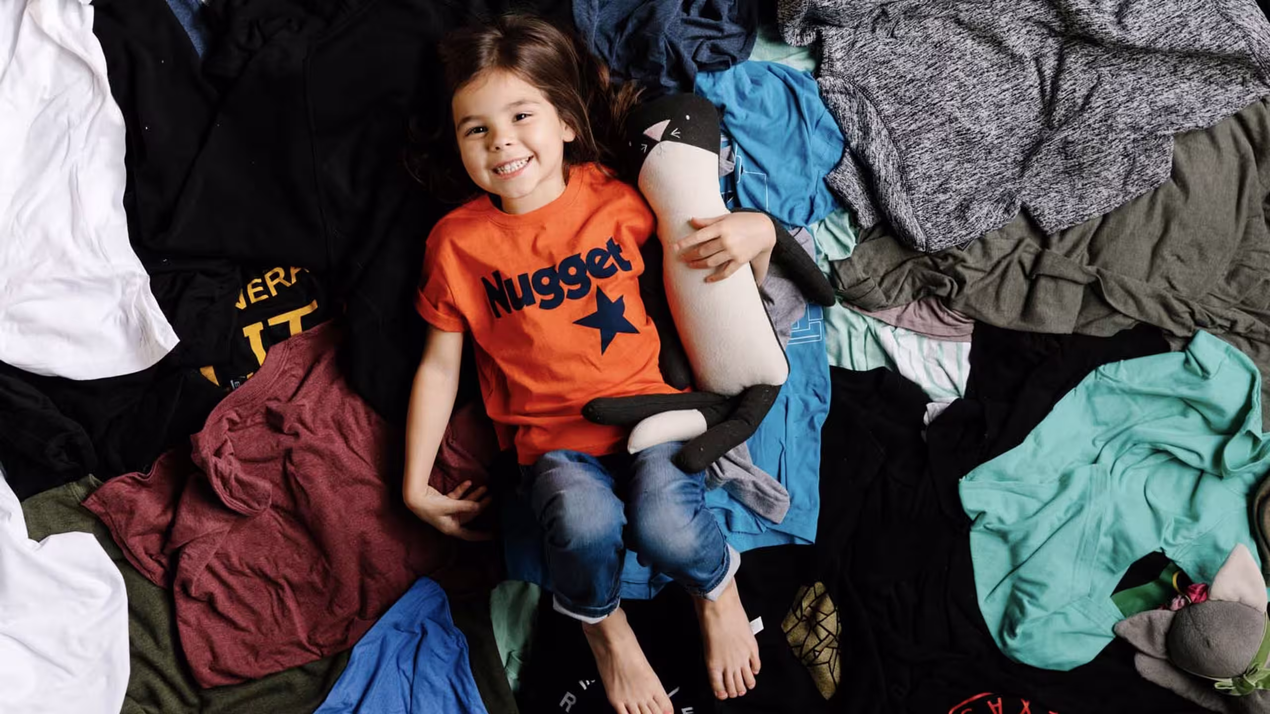 kid laying in t-shirts