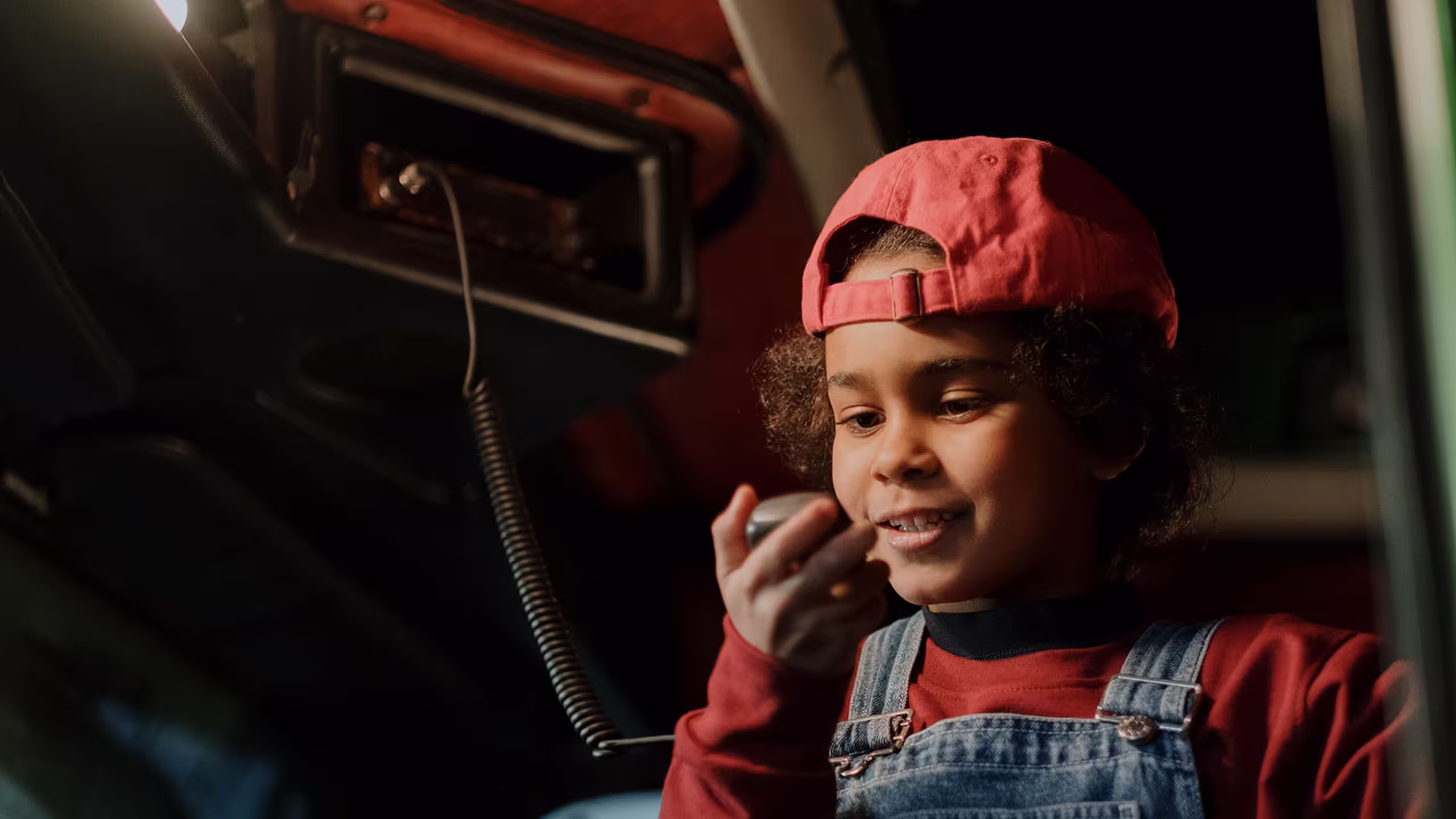 little boy with a red hat in a truck