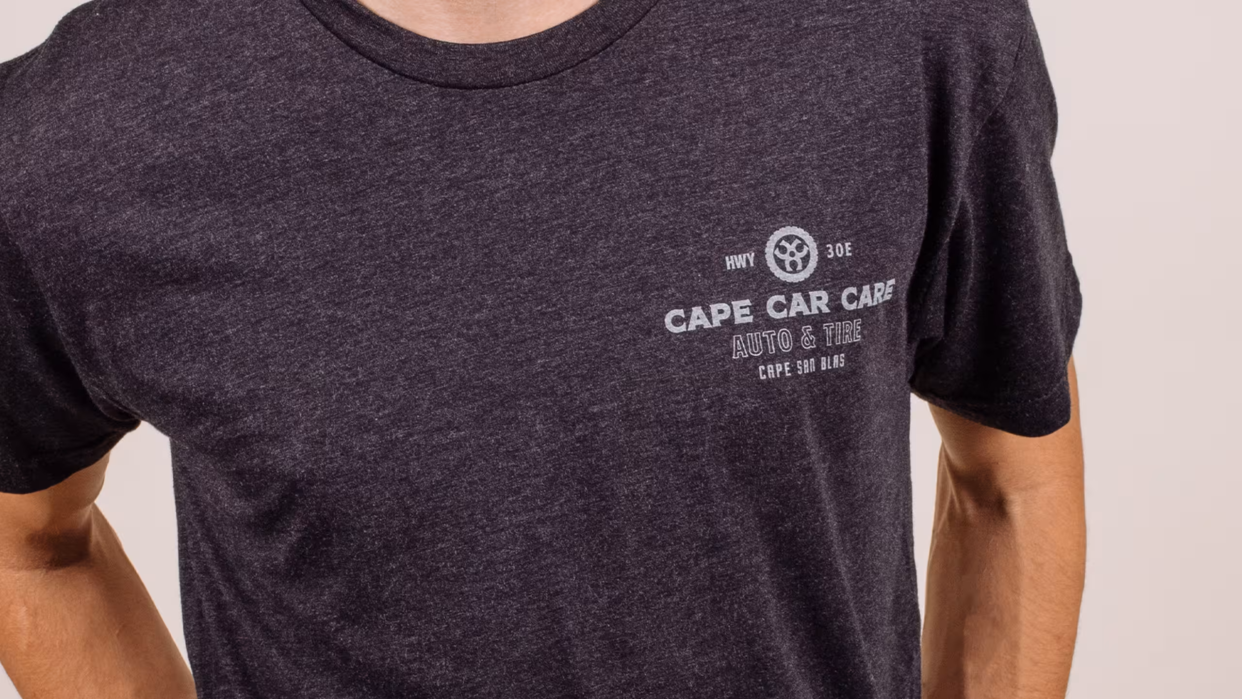 Gray shirt with a car logo printed on it. 