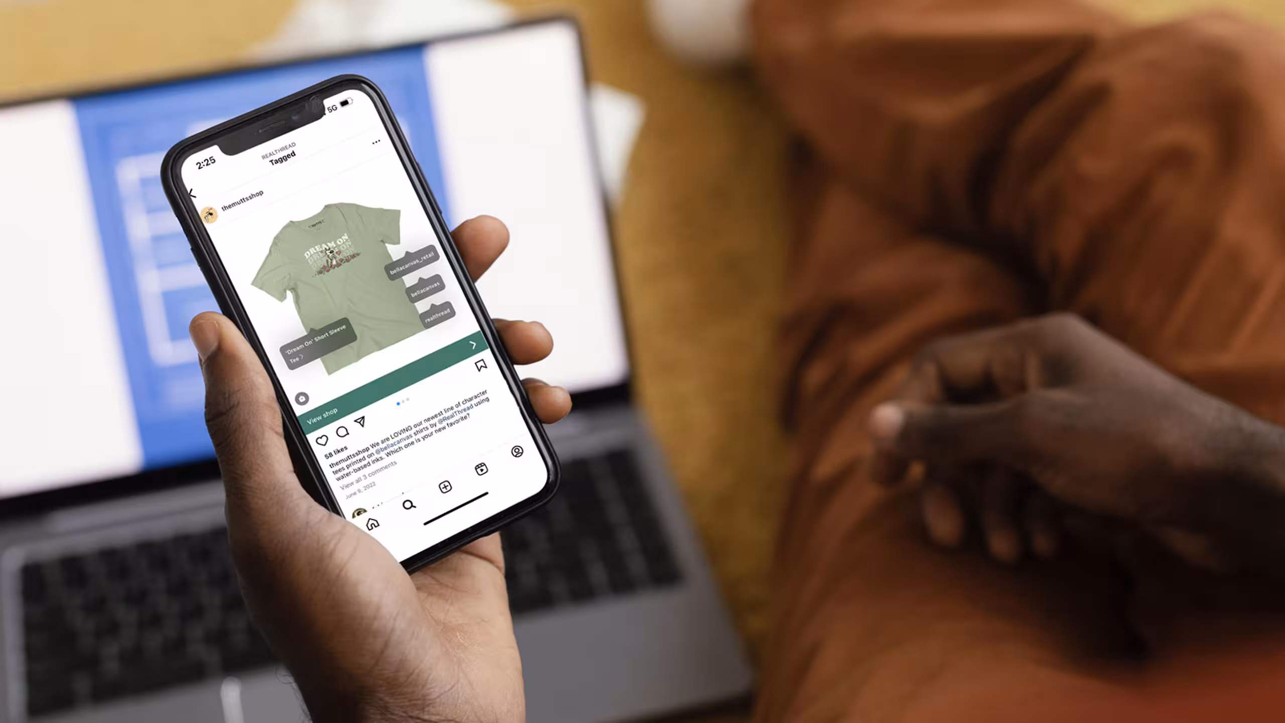 A person holding an iPhone with Real Thread's Instagram on it.