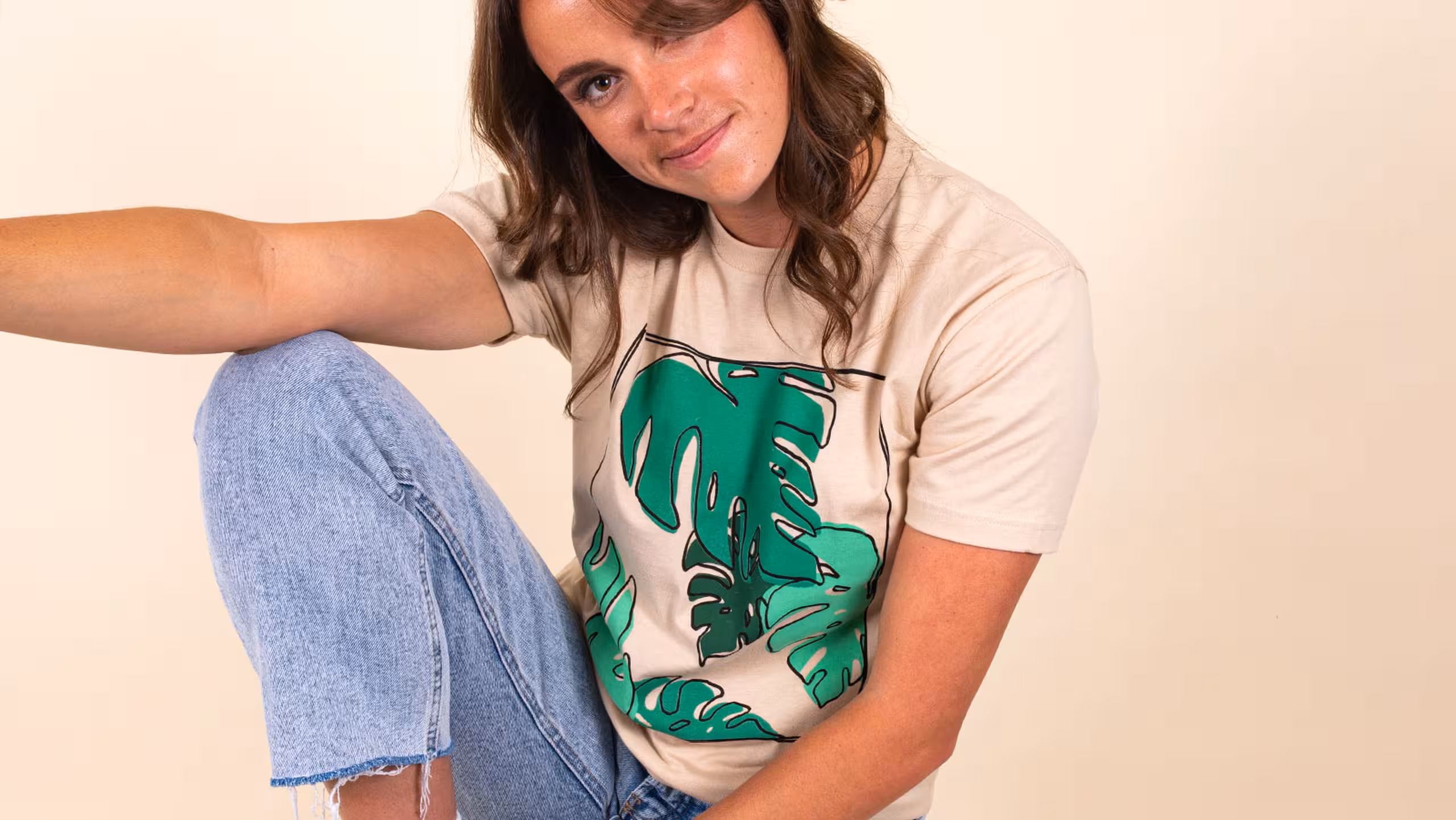 women wearing a cream color t-shirt with illustrated leafs