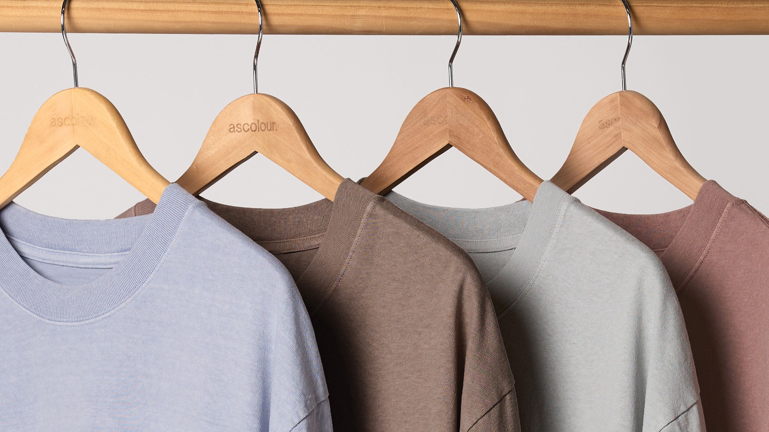 four heavyweight t-shirts hanging on a wooden hangers