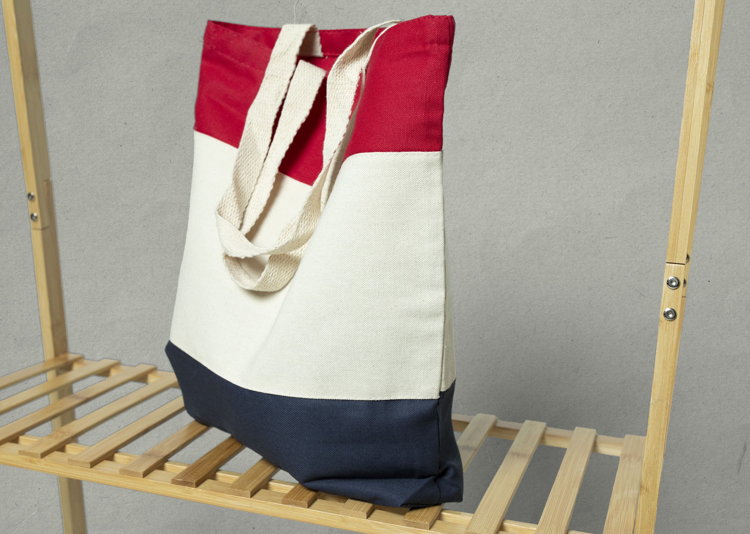 blue natural and red tote bag on a wood shelf