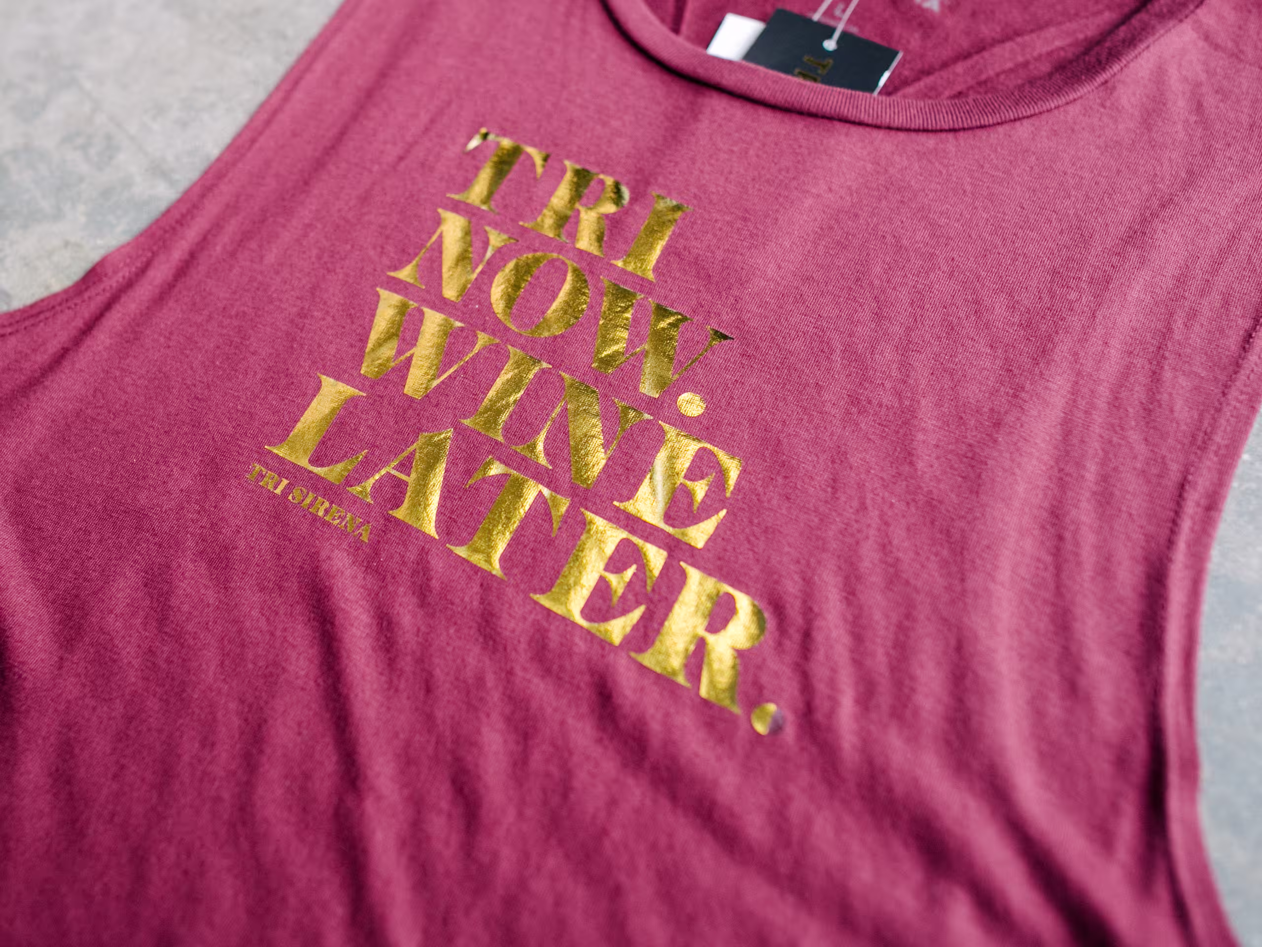 Red tank top with gold foil printing saying "Tri Now. Wine Later."