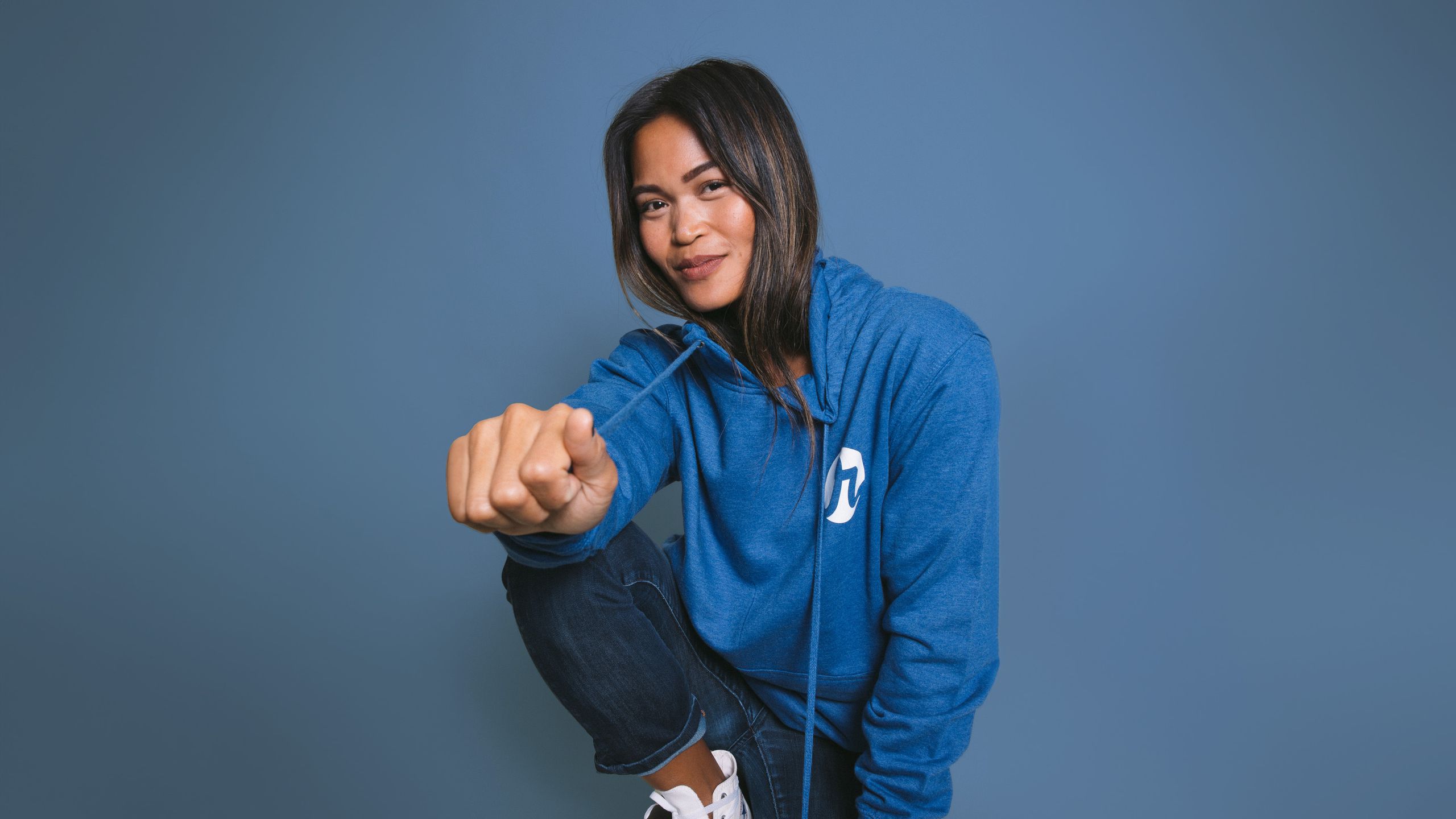 women kneeling with a blue hoodie on
